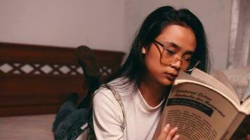 Aziatisch vrouw ontspannende en lezing een boek in een retro kamer video