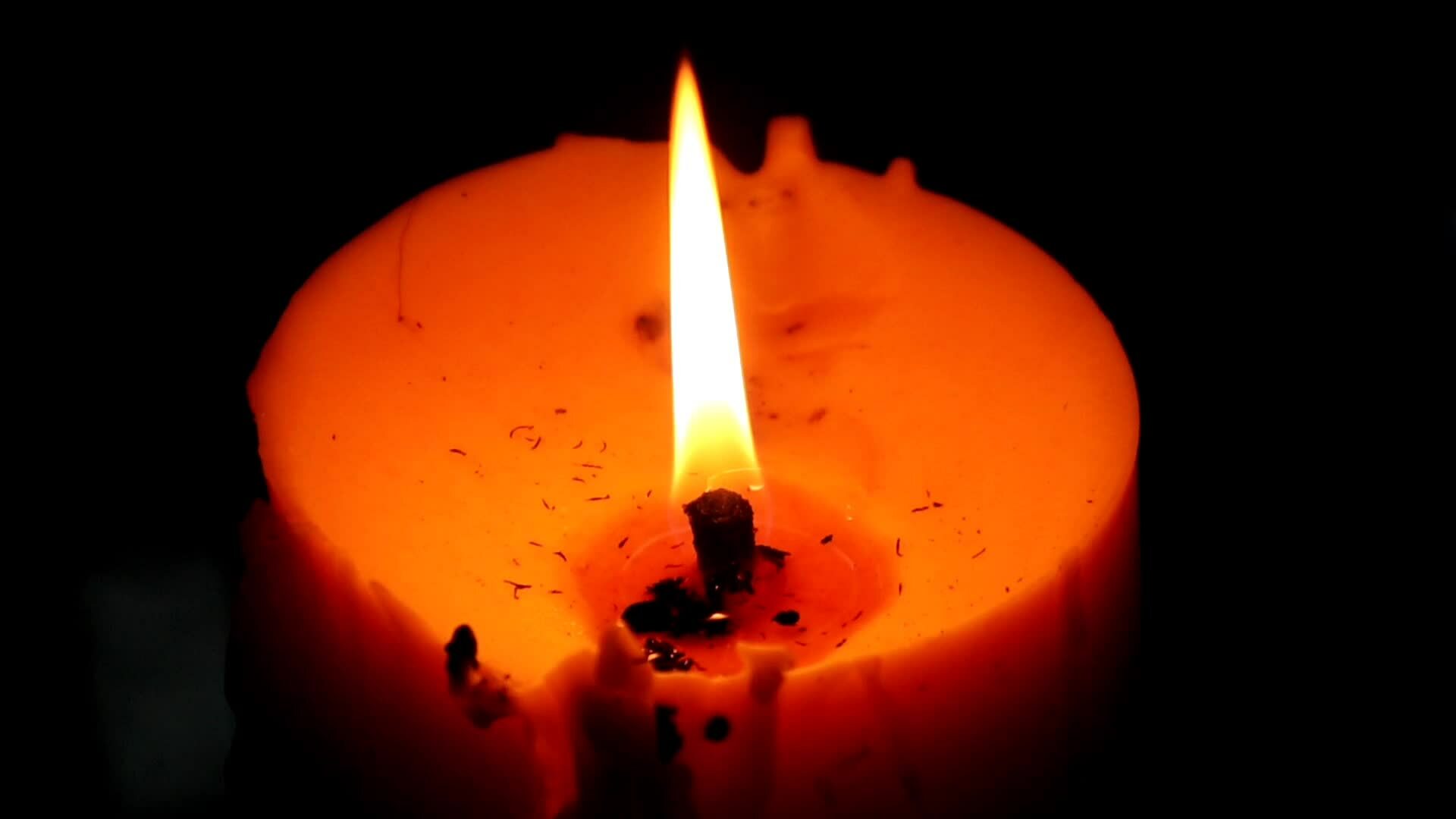 Close up view of the candles cutting through the darkness. 26616653