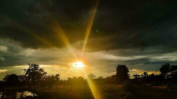 The light from the setting sun shone from the clouds. photo