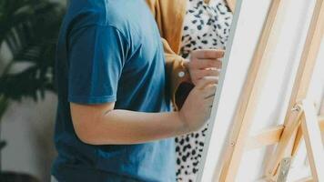 kinderen zus en broer spelen tekening samen Aan verdieping terwijl jong ouders ontspannende Bij huis Aan bank, weinig jongen meisje hebben plezier, vriendschap tussen broers en zussen, familie vrije tijd tijd in leven kamer video