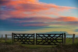 un cerca con un portón y un cielo en el antecedentes foto
