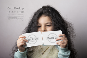 wenig Mädchen Porträt halten zwei Blitz Karte im Vorderseite von Gesicht psd