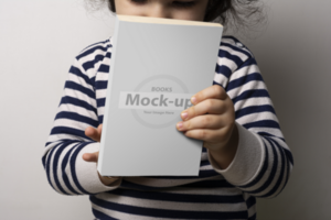 pequeño niña participación un novela libro con blanco cubrir en frente de cuerpo psd