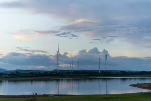 Evening view of windmill fields on water surface and beautiful sky in Chaiyaphum, Thailand. photo