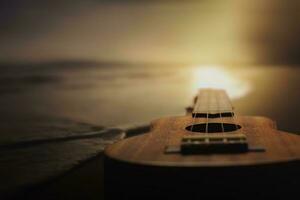 Ukulele on beach at sunset photo