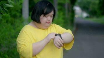 Asian girl with down syndrome look at the clock and rejoicewhile exercising in the park video