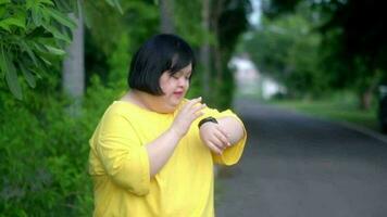 Looking at the clock, Asian girl with Down syndrome rejoicesAs I exercised in the park. video