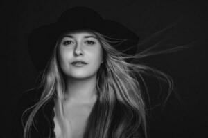 Beautiful blonde woman wearing a hat, artistic film portrait in black and white for fashion campaign and beauty brand photo