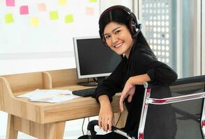 Asian business woman Video Conference for talk to colleagues work from home office wear headphones,  girl student talking by video conference call, female teacher trainer from home at living room photo