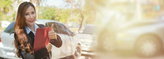 Asian women are insurance agents holding clipboards and standing in front of car accidents after checking car damage, Concepts of insurance, and car traffic accidents. photo