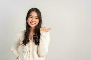 Portrait of attractive cheerful girl demonstrating and pointing finger to the side empty space isolated white background, showing advertisement, standing against. Advertisement presentation concept photo