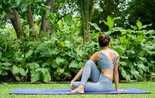 retrato de un joven mujer haciendo yoga en el jardín para un ejercicio. concepto de estilo de vida aptitud y saludable. asiático mujer son practicando yoga en el parque. foto