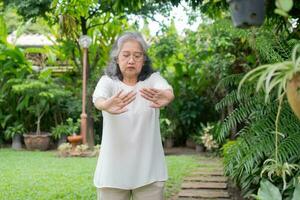 Portrait of a Asian Senior woman doing yoga and stretching exercise in the garden for a workout. Concept of lifestyle fitness and healthy. Asian women are practicing yoga in park. Healthy lifestyle photo