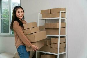 felices jóvenes empresarios asiáticos están organizando cajas para entregar productos a los clientes. propietario de una pequeña empresa y éxito en conceptos de negocios en línea. foto
