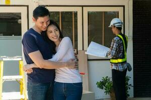 Happy and Smiling couple stand in front of constructor, handyman holding blueprint and checking details before renovations home, house improvement interior, Interior design, specialist concept photo