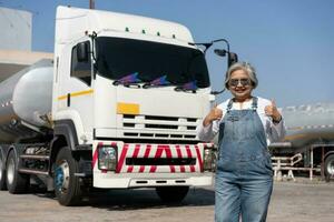 Business owner standing in front of oil truck after performing a pre-trip inspection on a truck. Concept of preventive maintenance. photo