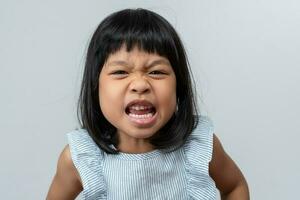 Portrait of angry emotional Asian girl screaming and frustrated shouting with anger, crazy and yelling on white background, Concept of attention deficit hyperactivity disorder ADHD photo