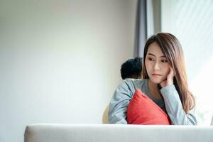 Unhappy Couple sitting behind each other on the couch and avoid talking or looking at each other, Cause of relationship problems and having misunderstanding or disagreement. Family problems concept photo