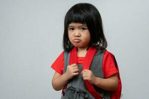 Portrait of Asian angry and sad little girl on white isolated background, The emotion of a child when tantrum and mad, expression grumpy emotion. Kid emotional control concept photo