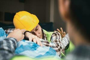 Foreman user radio to nurse for first aid Construction worker faint in construction site because Heat Stroke. Worker with safety helmet take a nap because so are tired from working in the hot sun photo