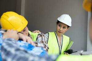 Foreman user radio to nurse for first aid Construction worker faint in construction site because Heat Stroke. Worker with safety helmet take a nap because so are tired from working in the hot sun photo