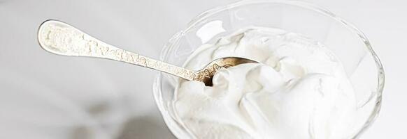 White whipped dessert cream served in a glass bowl, creamy texture photo