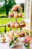 Cupcakes, cakes, scones and muffins and holiday decoration outdoors at the English country style garden, sweet desserts for wedding, birthday or party celebration, generative ai photo