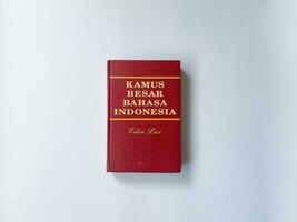 Yogyakarta, Indonesia, 26 Jan 2023 - A standard Indonesian language dictionary with a red cover, captured from a top-down perspective. photo