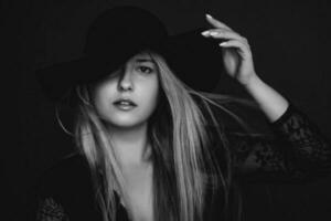 Beautiful blonde woman wearing a hat, artistic film portrait in black and white for fashion campaign and beauty brand photo