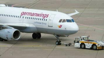DUSSELDORF, GERMANY JULY 23, 2017 - Middle shot, Germanwings Airbus pulls the tractor onto the runway before departure at Dusseldorf Airport DUS. Tractor pulls a passenger plane video