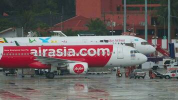 PHUKET, THAILAND DECEMBER 2, 2016 - AirAsia aircraft undergoing maintenance and servicing at Phuket International Airport, Thailand HKT. Rainy season in Phuket, Thailand. Tourism and travel concept video