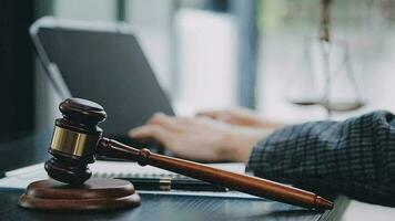 Business and lawyers discussing contract papers with brass scale on desk in office. Law, legal services, advice, justice and law concept picture with film grain effect video