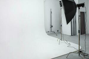 interior de espacio luminoso de estudio fotográfico con gran ciclorama blanco con equipo de iluminación foto