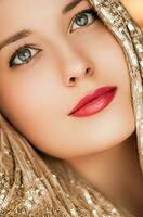 Beauty, luxury fashion and glamour, woman dressed in gold photo