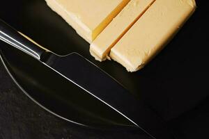 rebanado orgánico mantequilla bloquear y cuchillo, desayuno comida foto