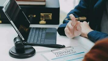 Business and lawyers discussing contract papers with brass scale on desk in office. Law, legal services, advice, justice and law concept picture with film grain effect video