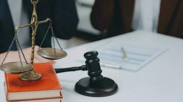 Business and lawyers discussing contract papers with brass scale on desk in office. Law, legal services, advice, justice and law concept picture with film grain effect video