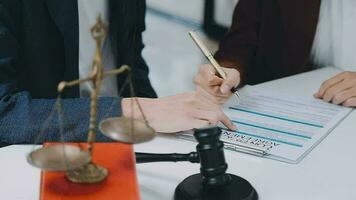 zaken en advocaten bespreken contractpapieren met koperen schaal op bureau in kantoor. wet, juridische diensten, advies, rechtvaardigheid en wet concept foto met film grain effect video