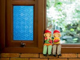 Couple dolls sitting by the window photo