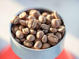 Roasted coffee beans in a funnel with coffee powder photo