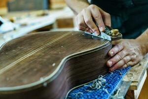 luthier masculino irreconocible elaborando guitarra flamenca española foto