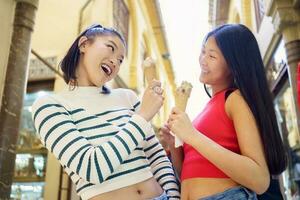 Smiling young Asian women with ice creams photo