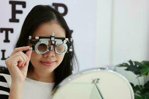 Lady wearing test glasses inside an ophthalmologist photo