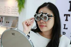 Lady wearing test glasses inside an ophthalmologist photo