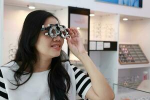 Lady wearing test glasses inside an ophthalmologist photo