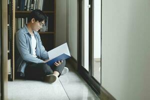 University students reading books in library for research. photo