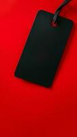 Black empty price tag on red background. Black Friday concept, template copyspace photo