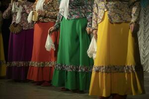 Folk costumes. Women perform on stage. Folklore ensemble. photo