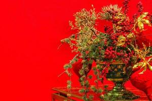 de cerca de Navidad árbol rama decoración en mesa de vivo habitación. guirnalda, dorado flores, luces y serbas en abeto abeto sucursales. invierno Días festivos composición con Copiar espacio foto
