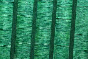 Texture of wooden crossbars. Wall of colored planks. Green fence. Interior slats background. The structure of the boards. Architecture striped panels photo